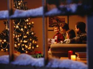 Family at Christmas viewed through window